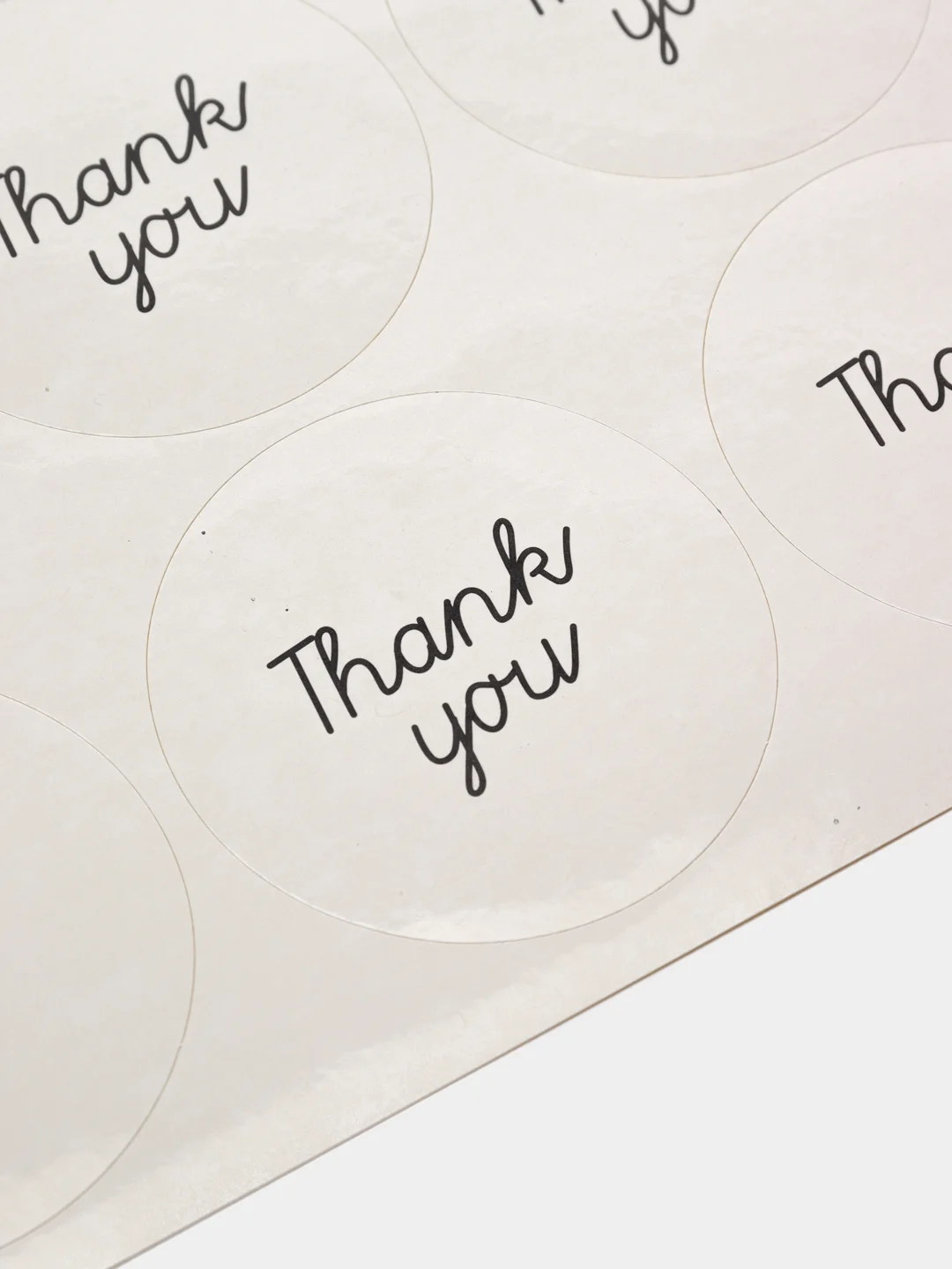 Круглая белая наклейка с надписью "Thank You"