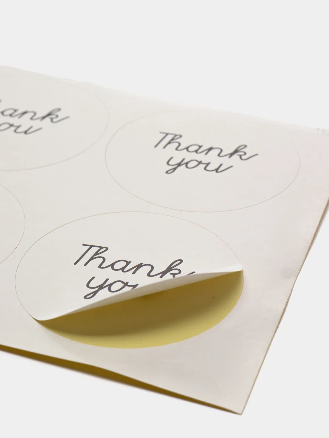 Круглая белая наклейка с надписью "Thank You"