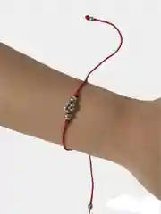 Браслет из красной нити с подвеской