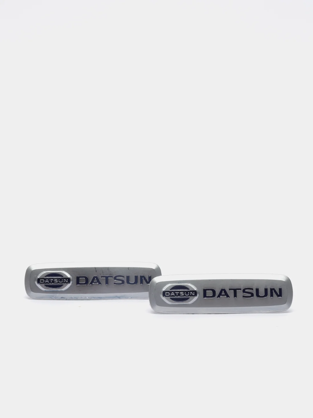 Комплект шильдиков металлических с эмблемой авто "DATSUN" и 4 винтовыми креплениями (Пара)