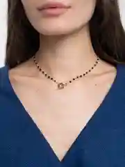 Золотой чокер из черных бусин.