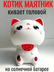 Белый котик удачи кивает головой в авто, в дом