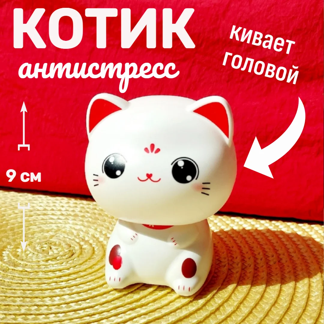 Белый котик удачи кивает головой в авто, в дом