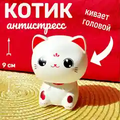 Белый котик удачи кивает головой в авто, в дом